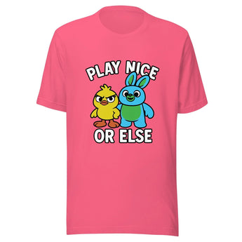 A pink t-shirt with a graphic design featuring two cartoon characters, a yellow duck and a blue rabbit, along with the text "PLAY NICE OR ELSE" above them.